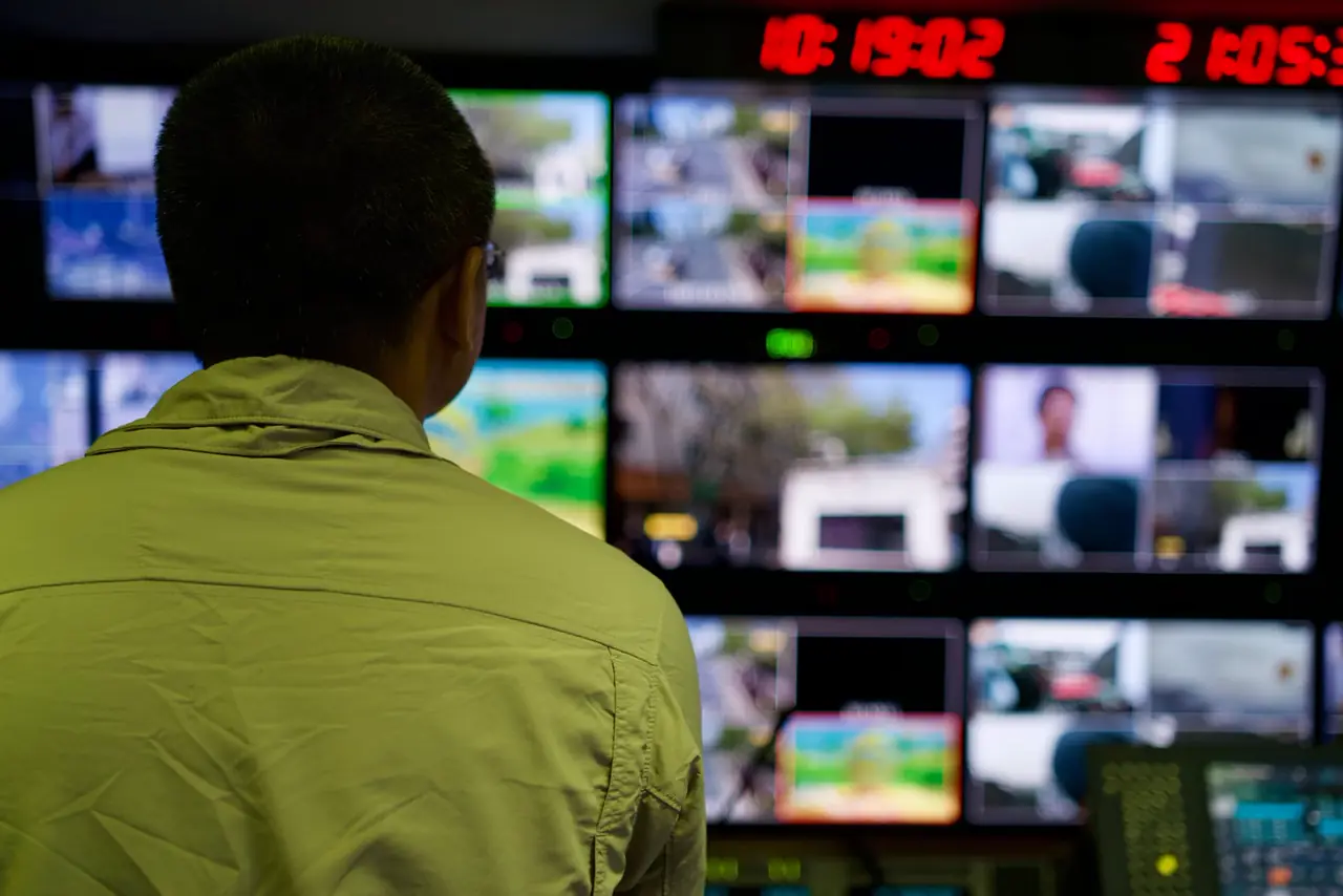 A TV studio control room with lit monitors.